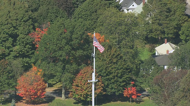 空中飘扬的美国国旗在战斗的绿色，与城市/莱克星顿，马萨诸塞州，美国视频下载