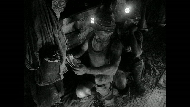 蒙太奇矿工在矿井中钻孔，并为炸药配线，而一名矿工在读一份杂志/英国的广告视频下载
