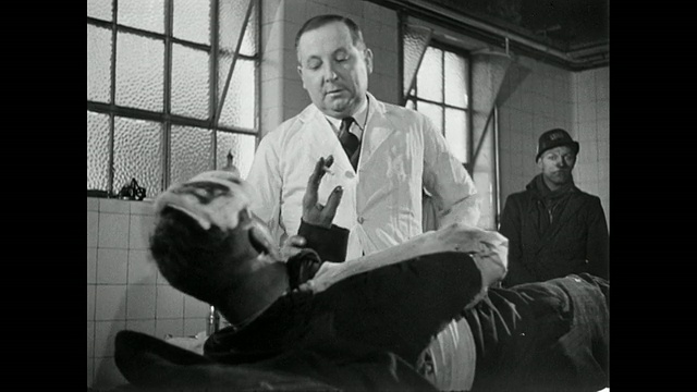 一名受伤男子躺在轮床上抽烟，医生告诉他要去医院/英国视频素材