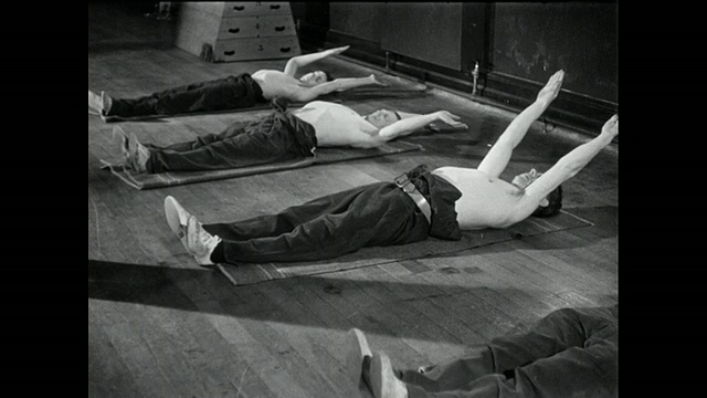 教练指导躺在地板上的人进行手臂伸展/英国视频素材