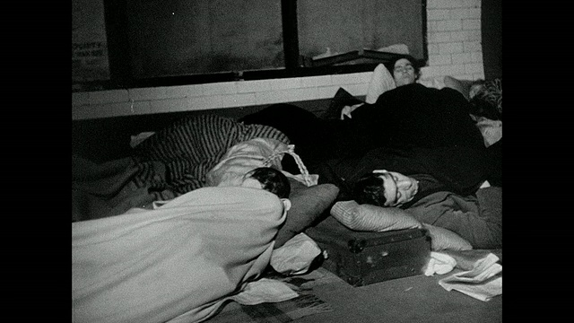蒙太奇家庭睡在地铁隧道作为防空洞，装饰圣诞树和母亲安慰小孩/英国视频下载