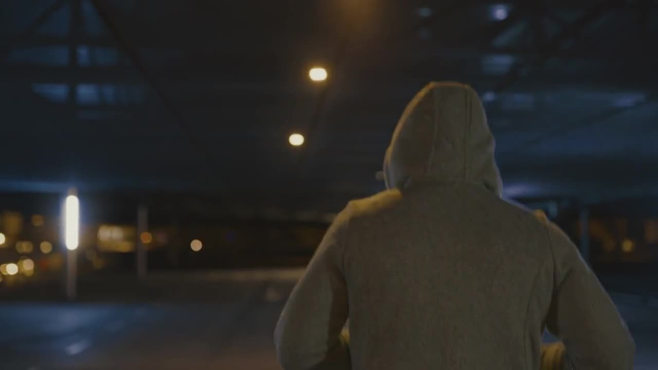 SLO MO兜帽慢跑者跑在一个空的停车场视频下载